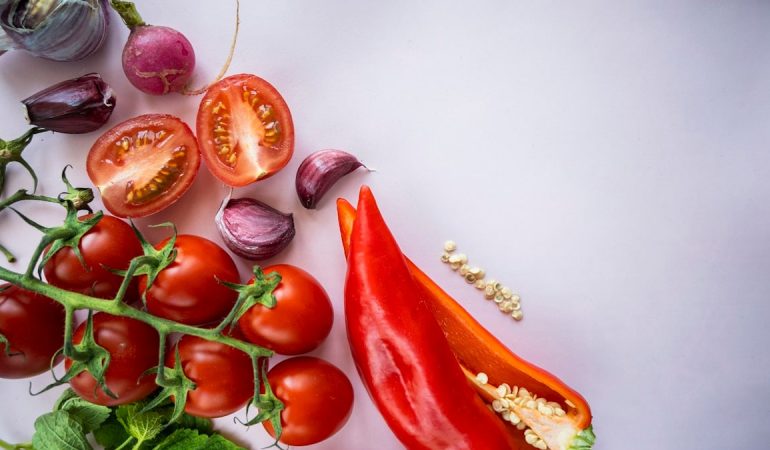 red chili and garlic on white surface